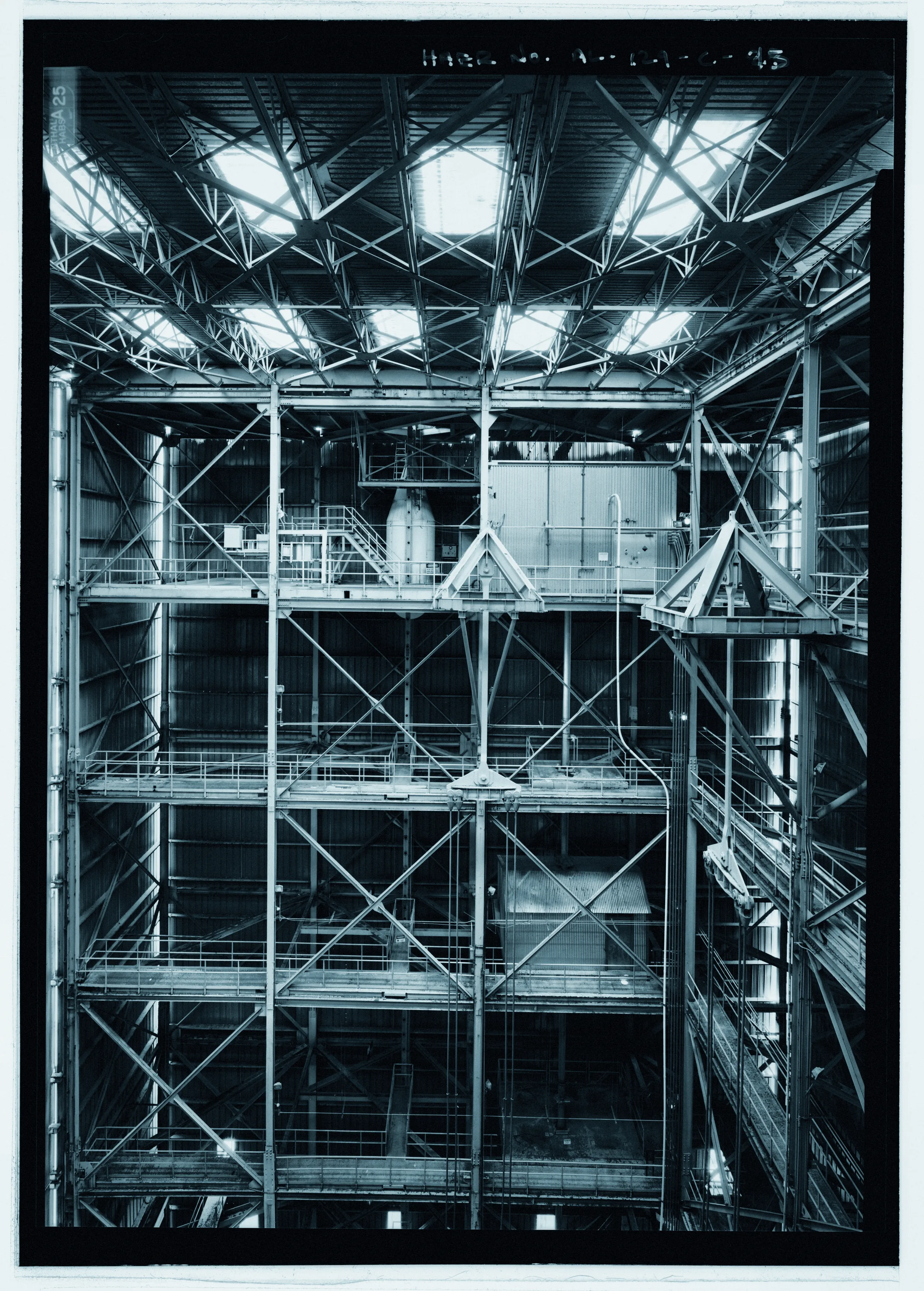 Elevation view of east wall from fifteenth level, west platform. Two hoisting supports are nested on the test stand structure in the background center and foreground right. -