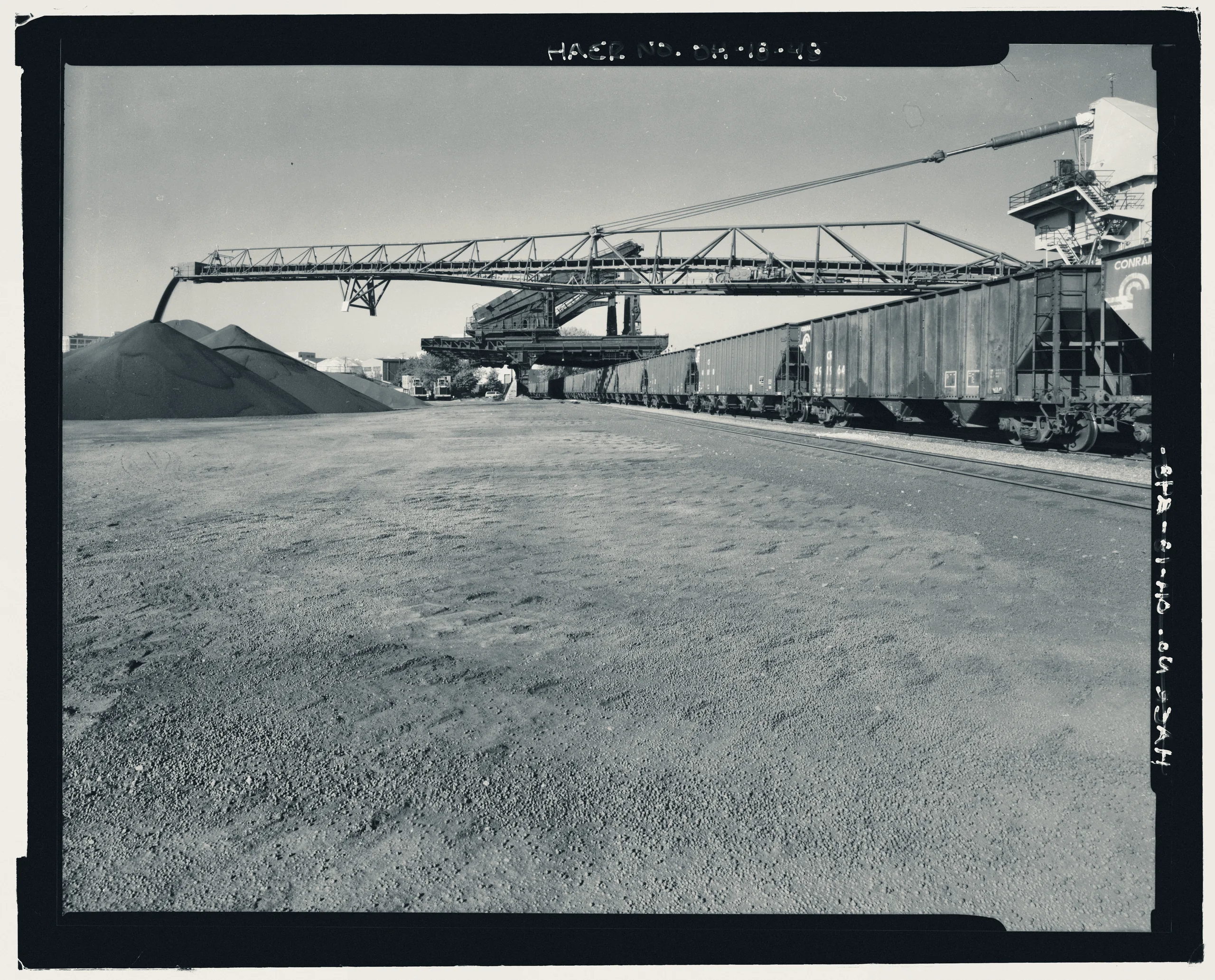 CONTEXT VIEW ACROSS ORE YARD AT MODERN SELF-UNLOADING BOOM IN FRONT OF HULETTS. LOOKING SOUTHWEST. - Pennsylvania Railway Ore Dock, Lake Erie at Whiskey Island, approximately 1