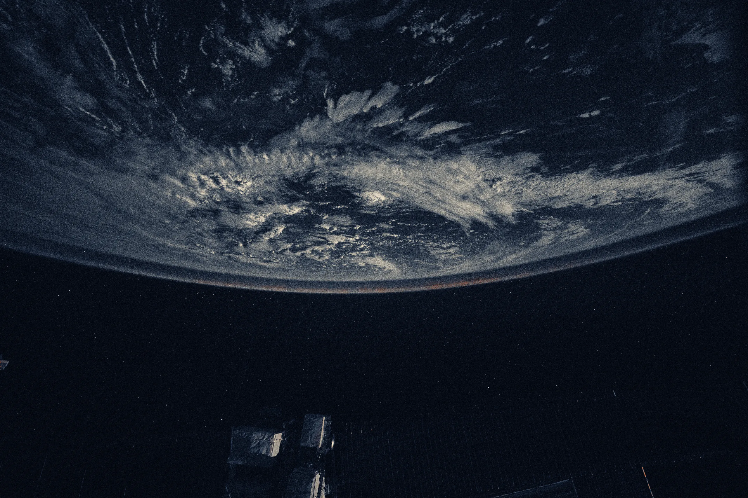 A faint airglow blankets Earth's horizon above the Pacific Ocean