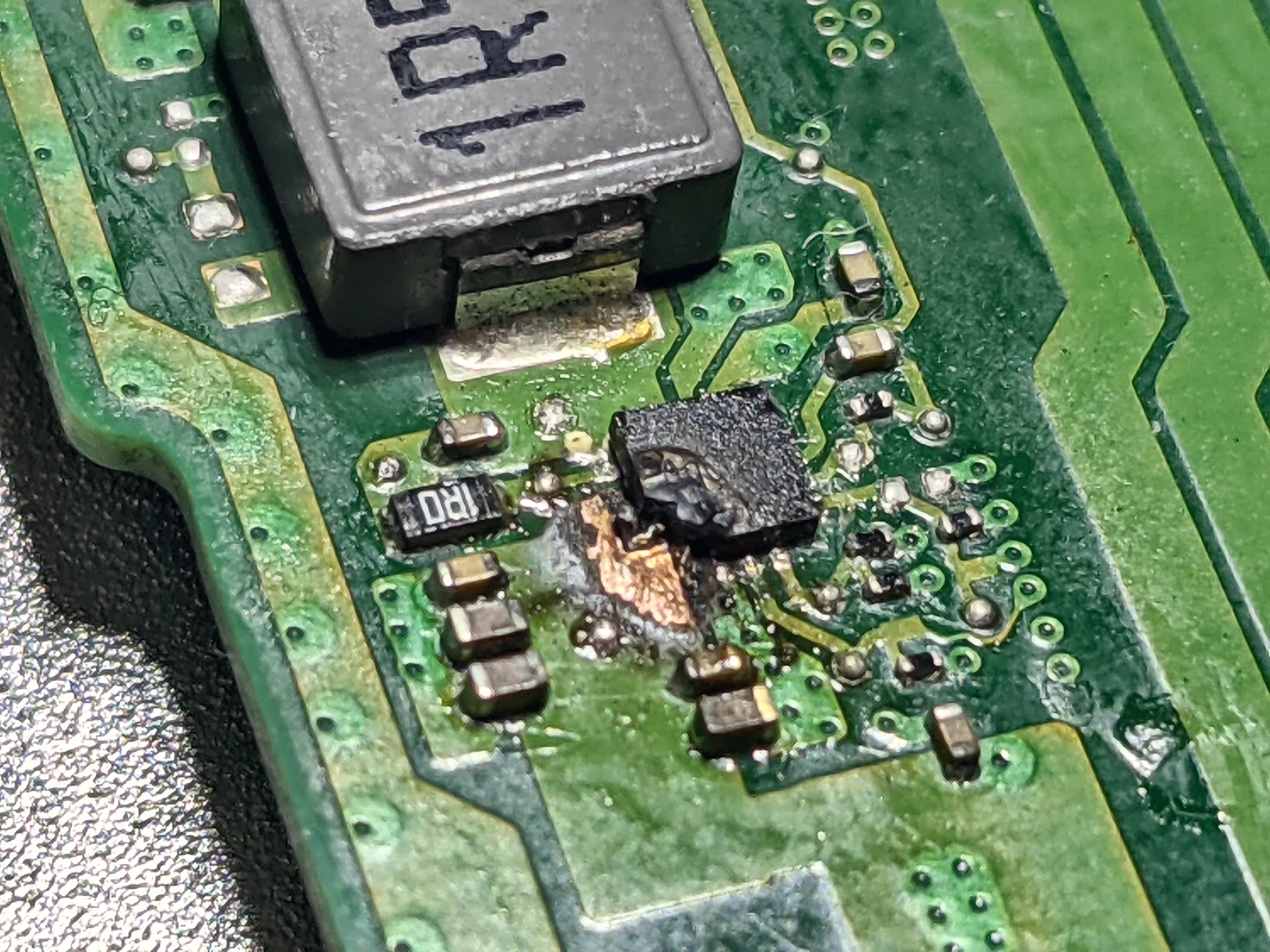 Microscope close-up of a blown step-down regulator on a laptop circuit board