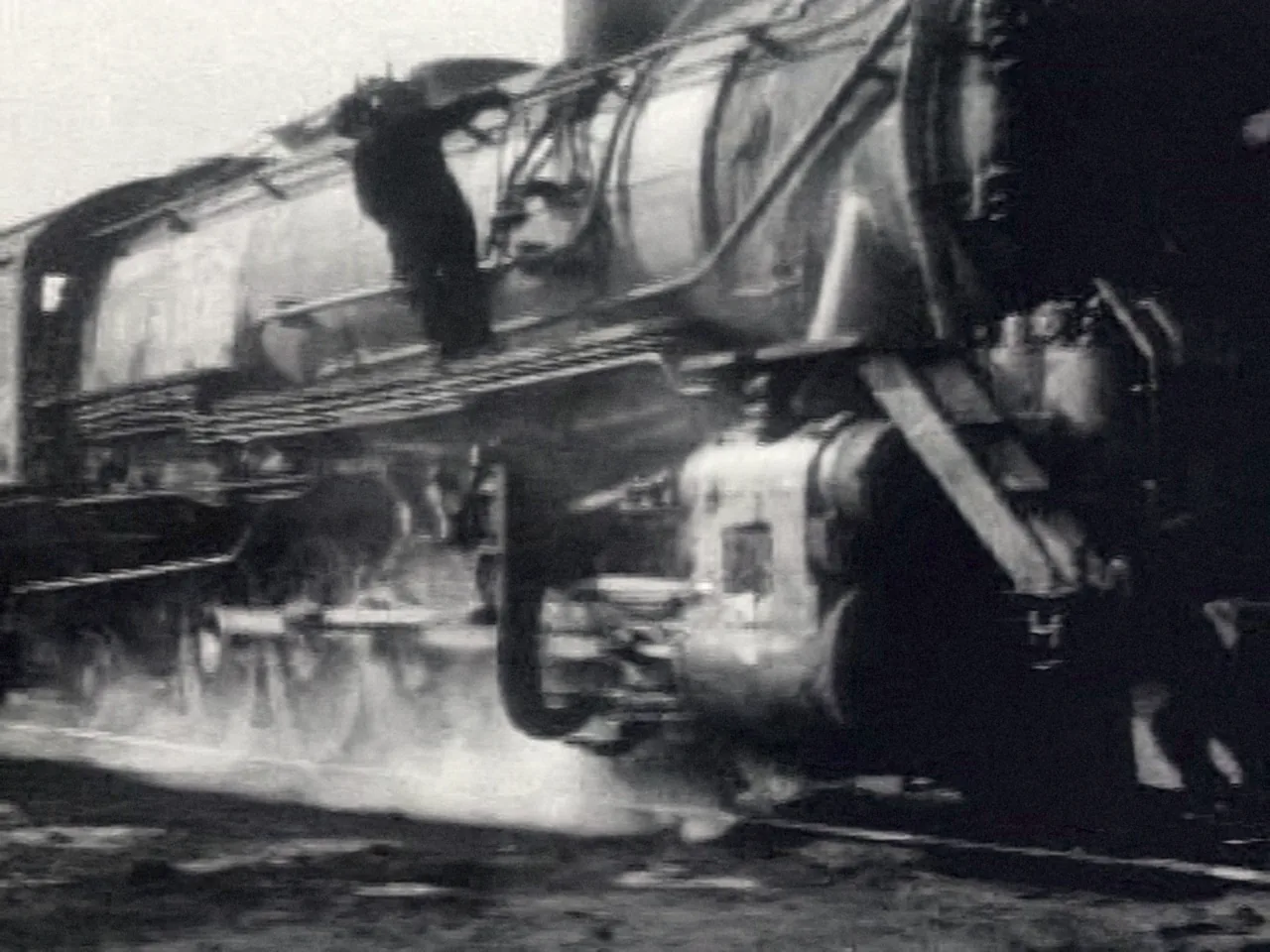 Locomotive driving wheels at speed — A Great Railroad at Work (1942)